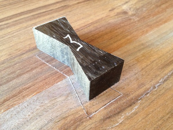 Trace the outline of the butterfly with a marking knife. Then use a putty knife to slowly and safely pry up the inlay. Remove the carpet tape.